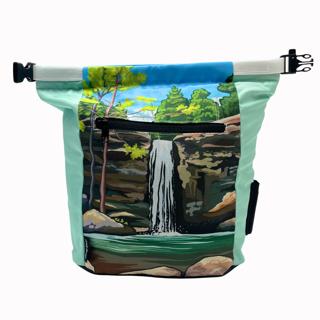 Gnarly Dood chalk bucket with Jackson Falls landscape graphic, velcro lid, carry handle, and zippered side pockets